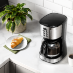 Cafeteira Elétrica Electrolux ECM30 em aço escovado com painel digital frontal e jarra de vidro cheia de café.